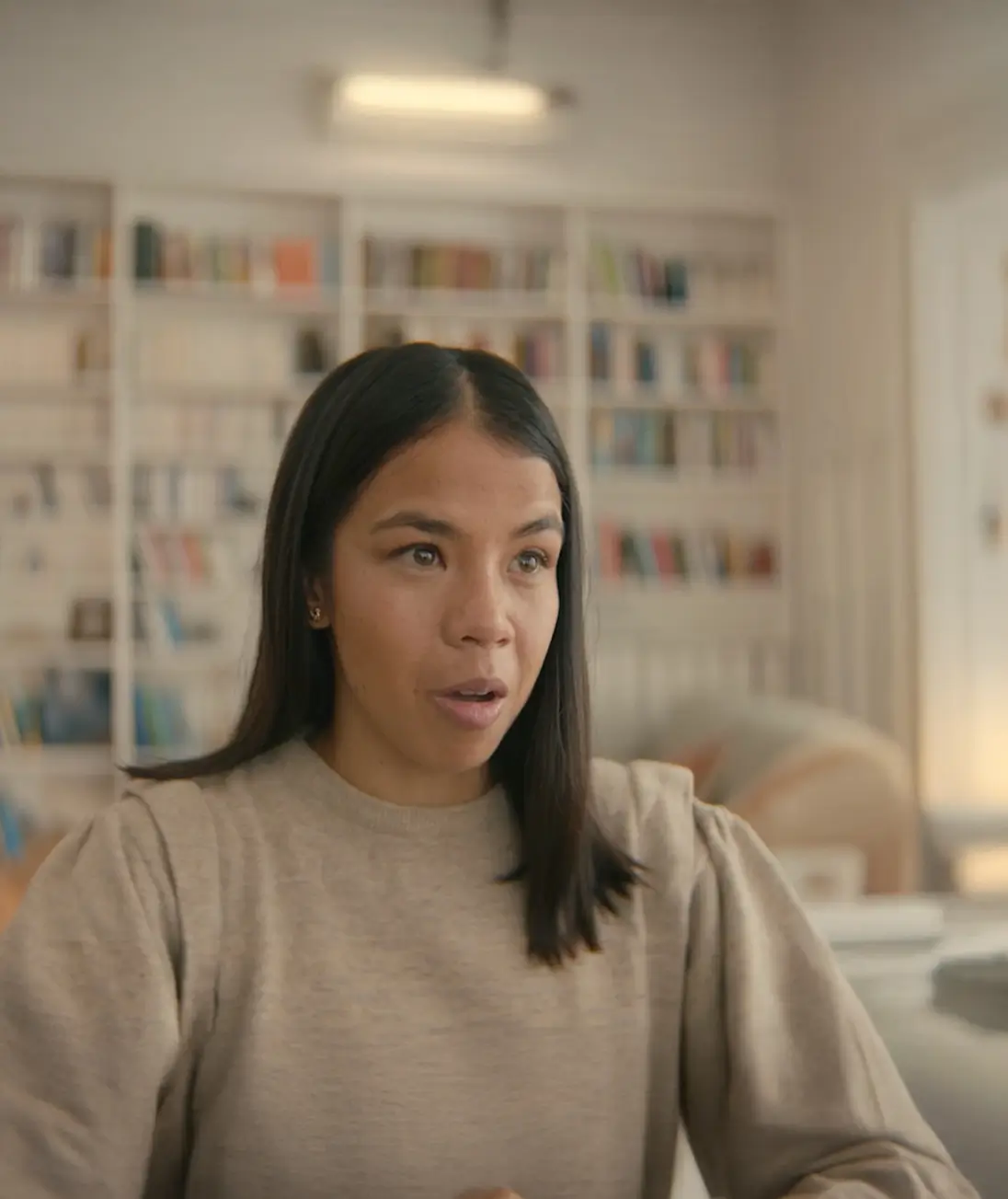 Woman speaking with bookshelves in the background