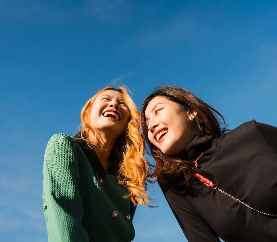 deux femmes souriant dehors