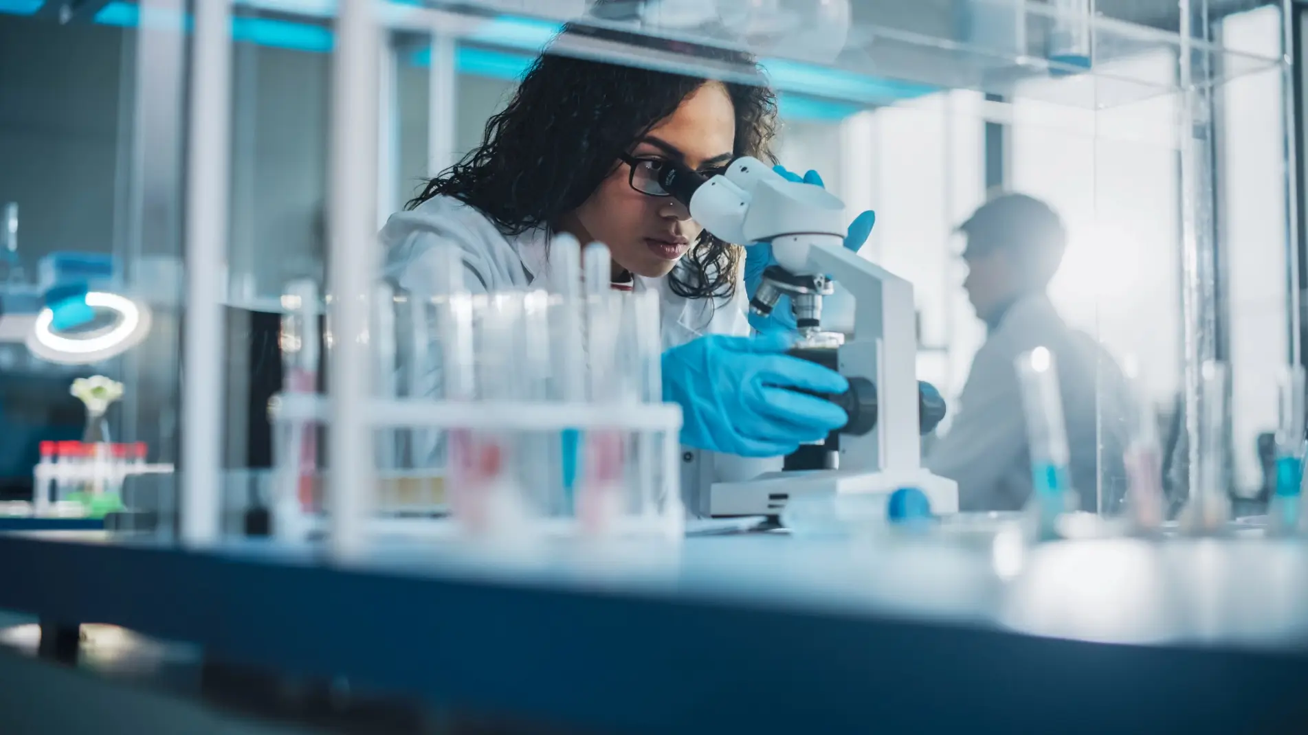 Científica usando un microscopio en un laboratorio.